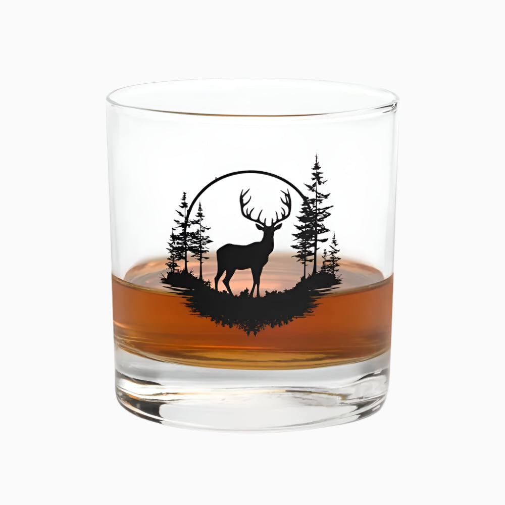 The 10.5 oz Deer Treeview Rocks Glass is a whiskey or bourbon glass featuring a black silhouette of a deer and trees on the side.