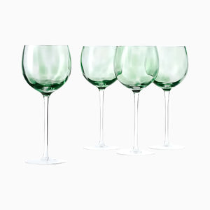 Set of 4 handmade 10 oz Blue Rose Polish Pottery Green Confetti large wine glasses, each with long stems, arranged in a row on a plain white background.