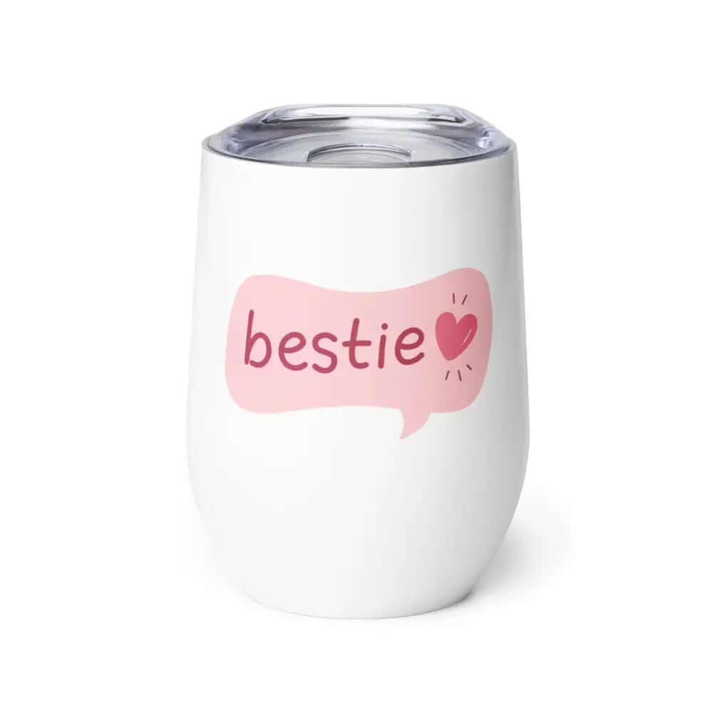 The 12 oz Bestie Wine Tumbler is a white stainless steel travel tumbler with a clear lid, featuring bestie and a pink heart in a speech bubble on the front.
