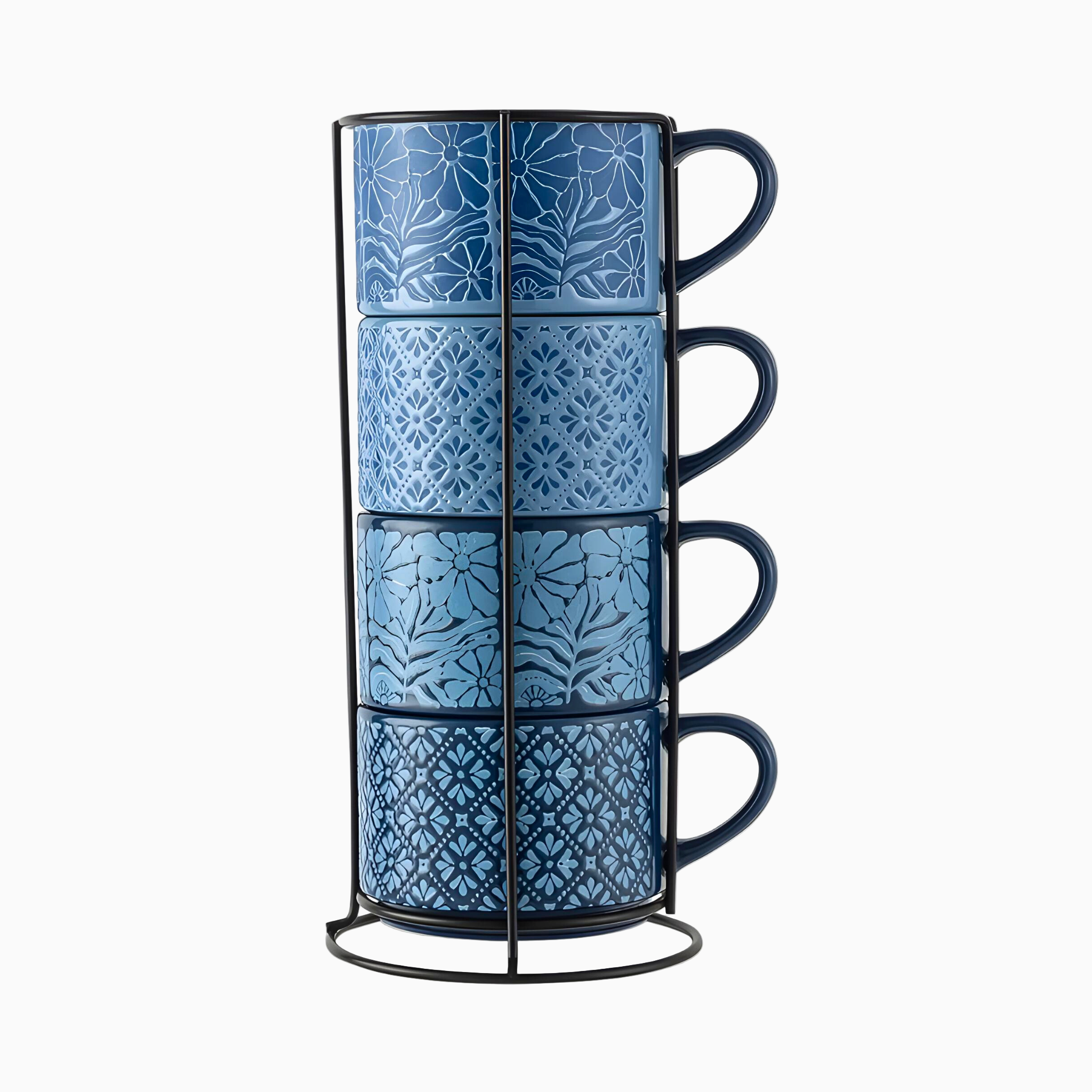 Four 11.1 fl oz stoneware stacking mugs with blue flowers and shapes are neatly arranged in a sleek black metal rack.