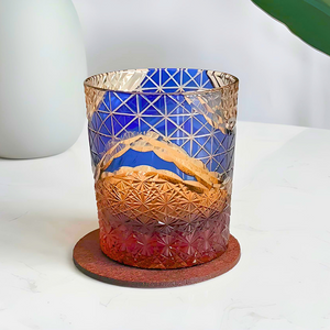 Decorative glass candle holder with geometric design on a white surface
