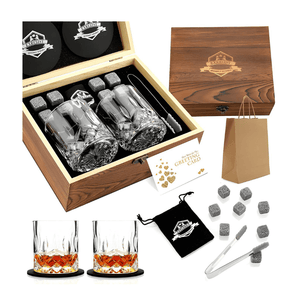 The Whiskey Stones Gift Set includes two crystal glasses, eight granite chilling whiskey rocks, metal tongs, coasters, a greeting card, a black pouch, and a wooden gift box—ideal for Father’s Day and comes with a brown gift bag.