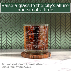 A 10 oz whiskey glass from the Whiskey Glasses - Tumbler Gift Set for San Francisco lovers rests on a wooden coaster, backed by patterned tiles. City map etching makes these glasses a unique gift choice.