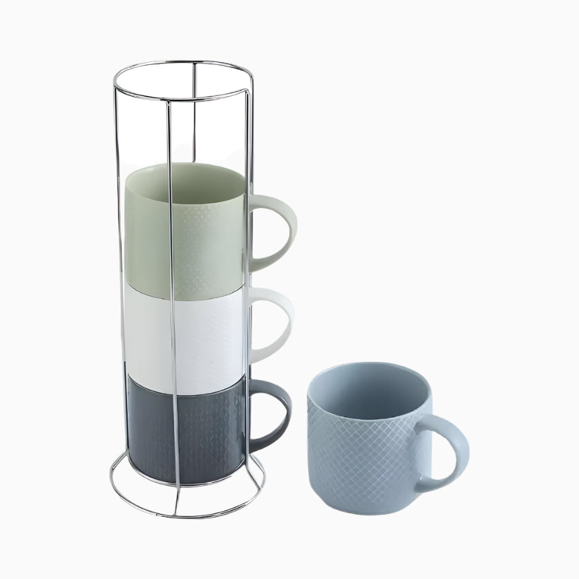 The Coffee Mugs Stackable Porcelain Coffee Cups Gift Set (15 Oz) features four colorful large mugs stacked in a metal holder, with one light blue ceramic latte cup displayed separately beside it.