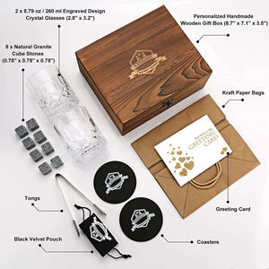 The Whiskey Stones Gift Set includes two engraved crystal glasses, eight granite chilling whiskey rocks, tongs, a velvet pouch, wooden box, coasters, kraft bag, and a greeting card—perfect gifts for men.