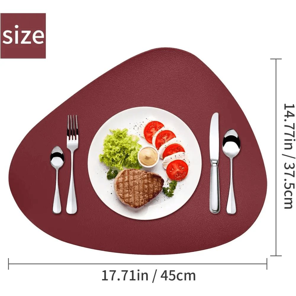 A steak and salad on a white plate sits atop maroon Round Placemats Set of 6 Faux Leather Placemats (17.71in x 14.77in), with utensils beside.
