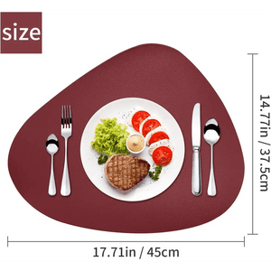 A steak and salad on a white plate sits atop maroon Round Placemats Set of 6 Faux Leather Placemats (17.71in x 14.77in), with utensils beside.