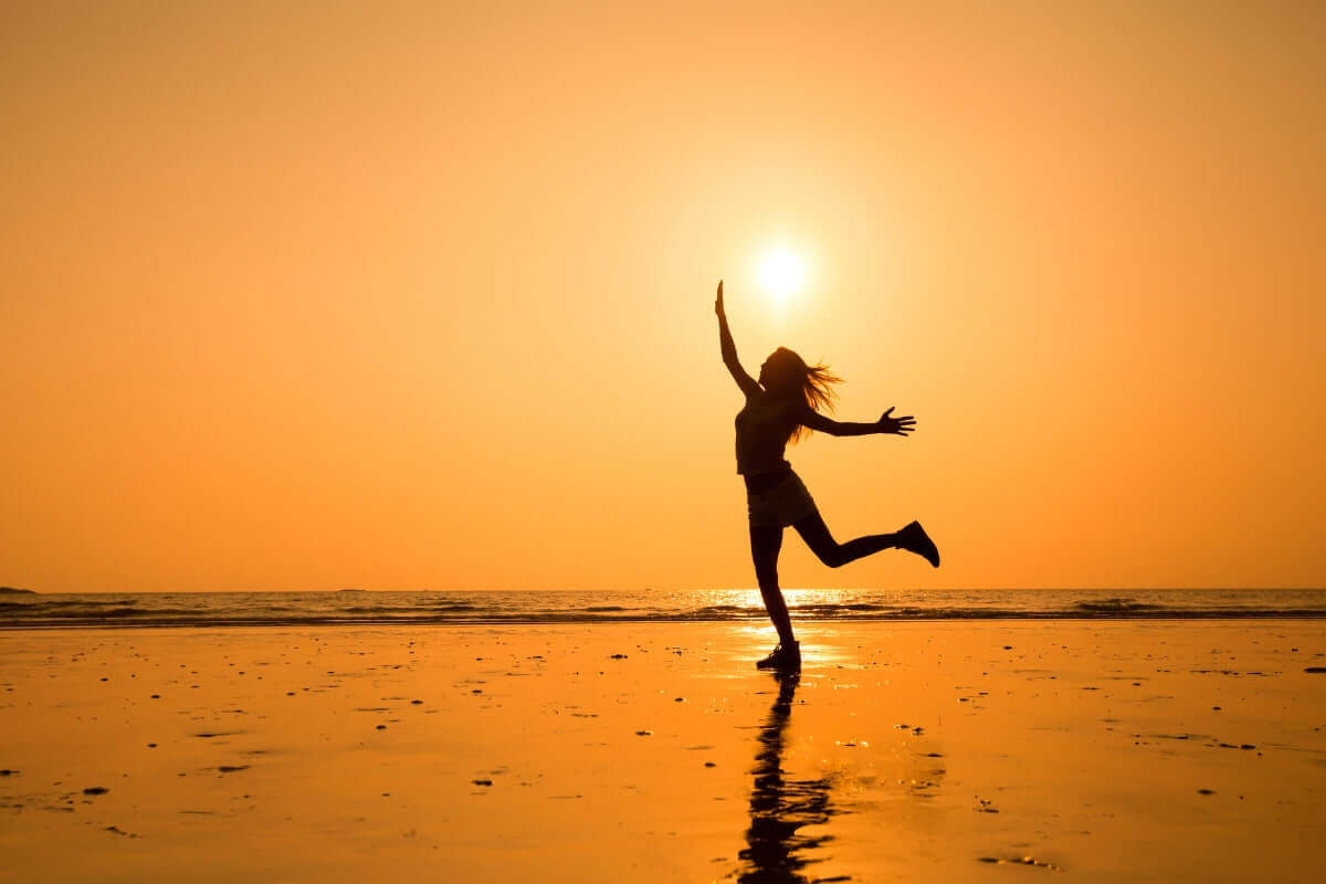 Image of a woman dancing on a beach