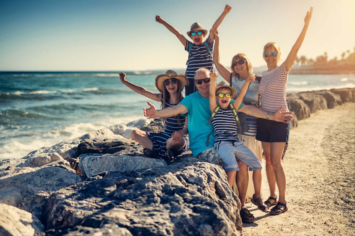 Image of a family on vacation with hands in the Y position