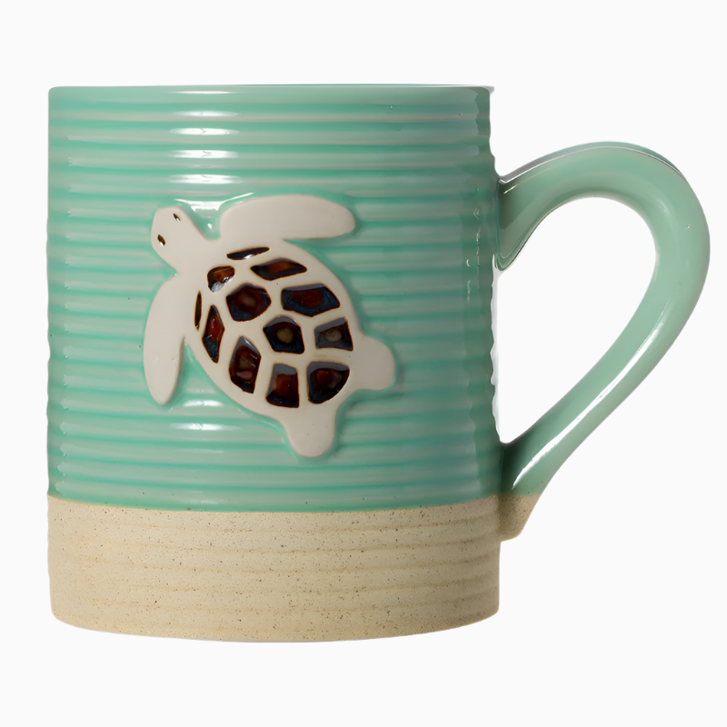 The 15oz Sandy Stoneware Pottery Mug (Turtle) features a light green ribbed texture, raised turtle design, and beige base, inspired by coastal style.