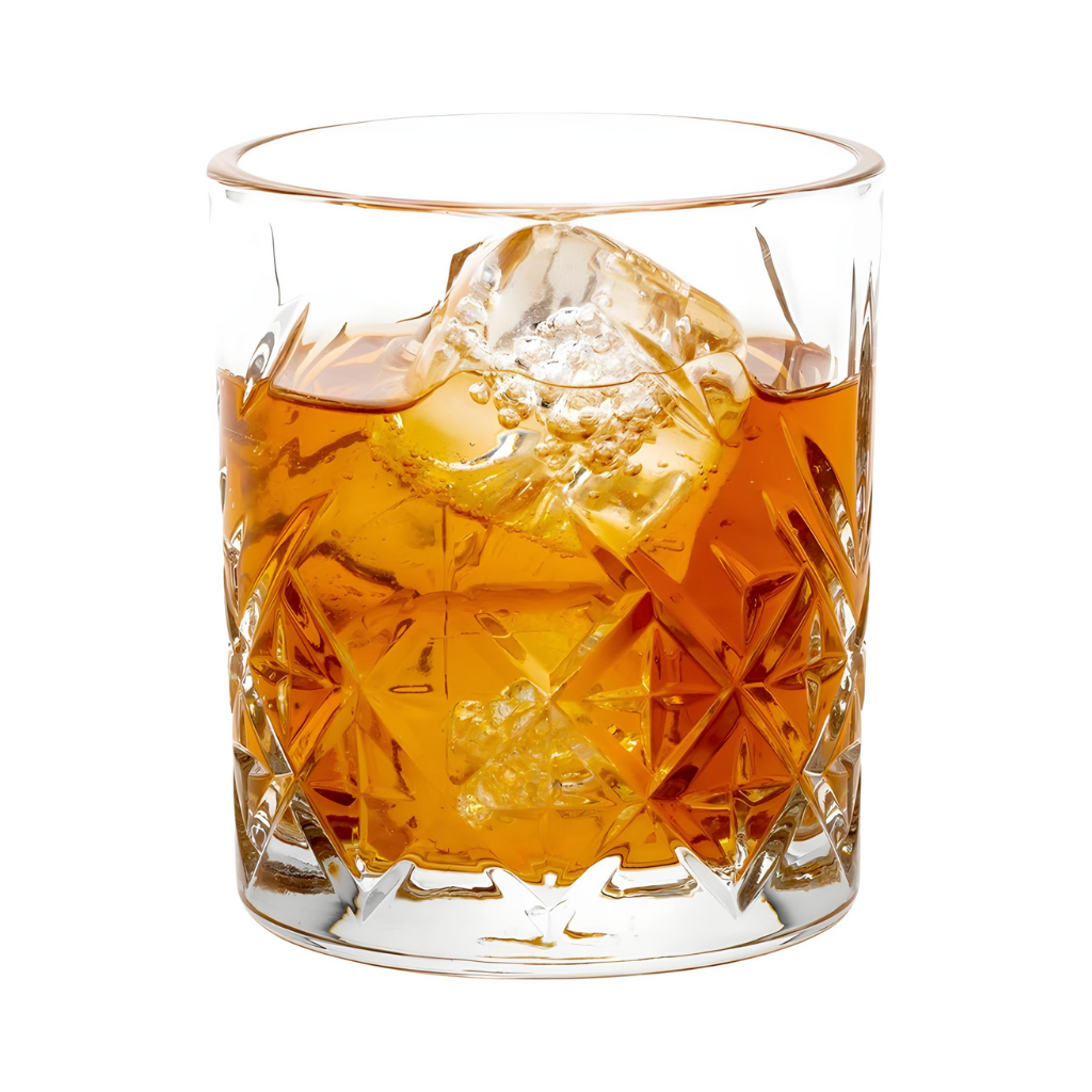 A glass of whiskey with ice in a 7 Ounce Rocks Glasses Set of 6 Etched Whiskey Glasses, made from clear, lead-free cut crystal, shown against a white background.