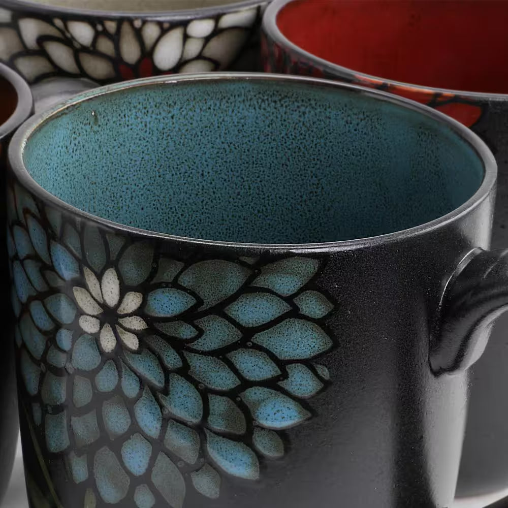 Close-up of Cafe 4-Piece Rustic Floral Vintage Earthenware Coffee Mugs, 16oz, featuring a striking blue and white floral design on a black background with a turquoise interior.