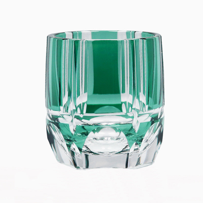 The Macchiaco Fashion Hand Carved Crystal Glass Cup features a faceted geometric design with green accents, highlighting modern simplicity. Photographed against a white background.