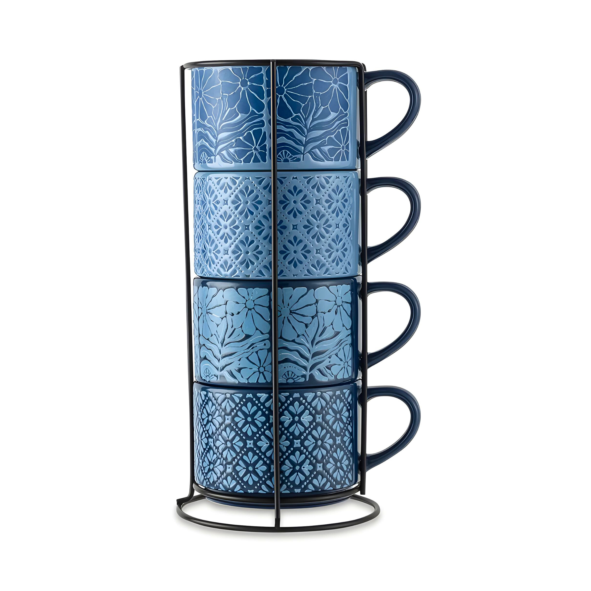 Four blue stoneware stacking mugs, each with a unique flower or shape pattern (11.1 fl oz), are held in a black metal rack.