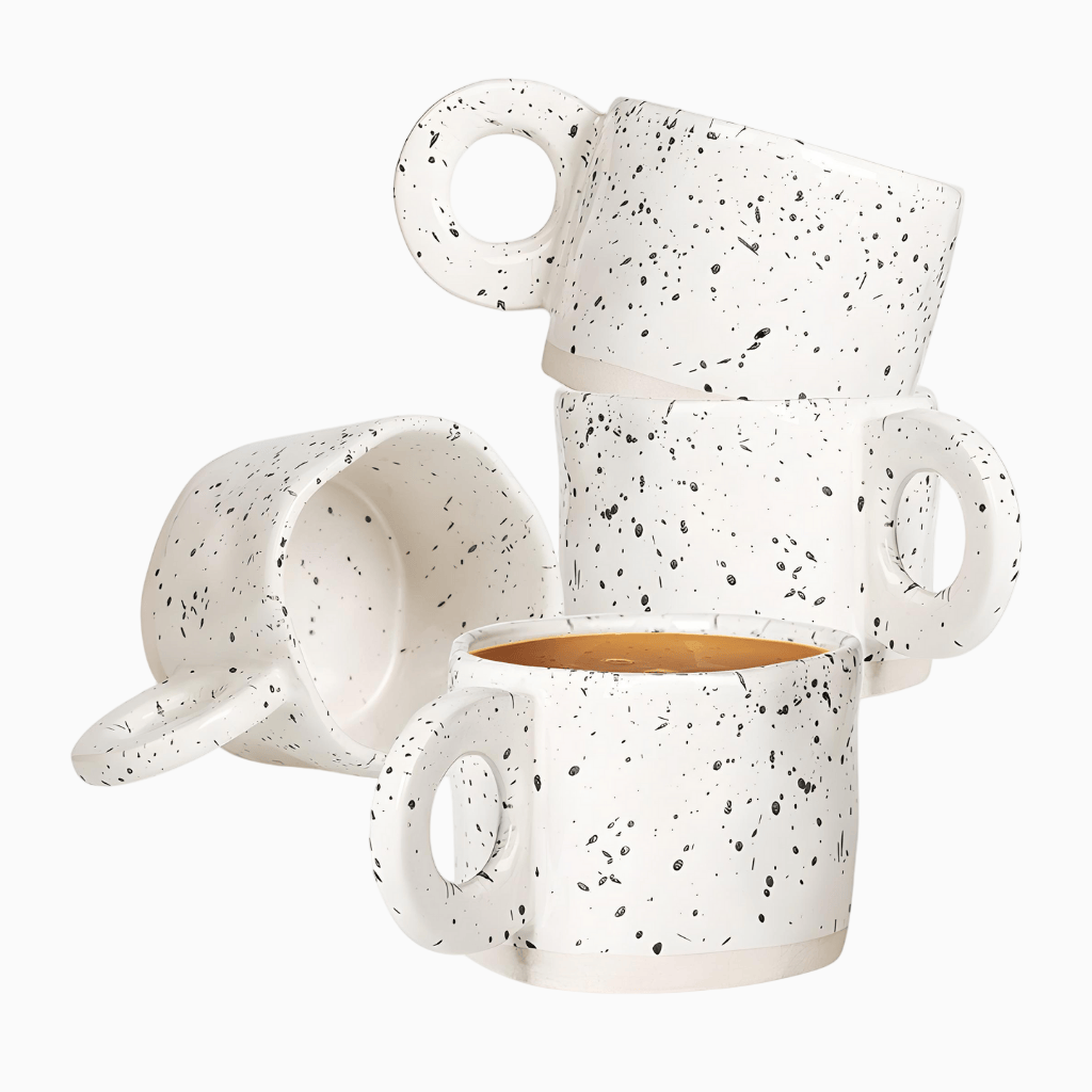 Set of three white speckled mugs on a white background