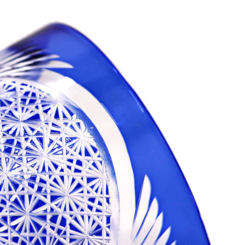 Close-up of the Macchiaco Amphora Hand-carved Whiskey Glass 8oz, showcasing intricate geometric and starburst patterns that reflect detailed Japanese craftsmanship and clear transparency on its curved surface.